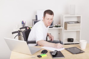 Man at computer desk filling out paperwork