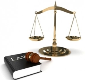Scales of justice with law book and gavel in foreground