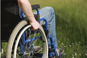 Man in wheelchair rolling on grass
