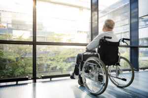 Man in wheelchair looks out window